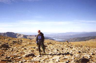 Lisa on top of the Divide with Grand Lake and Lake Grandby visible in the background.